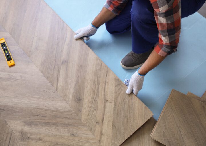 Homem instalando um piso laminado.