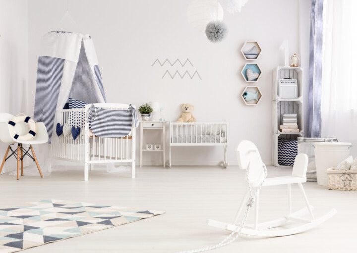 Quarto de bebê clean, todo em branco e detalhes em azul, com móveis funcionais.