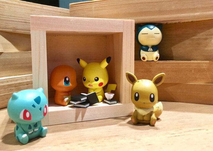 Foto que ilustra matéria sobre decoração Pokémon mostra pequenos bonecos da animação japonesa em um cenário de madeira