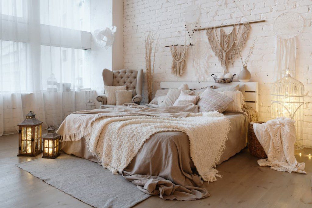 Quarto boho com decorações em macramê na parede.