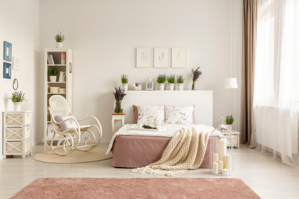 Quarto provençal branco com tapete-de-rosa.