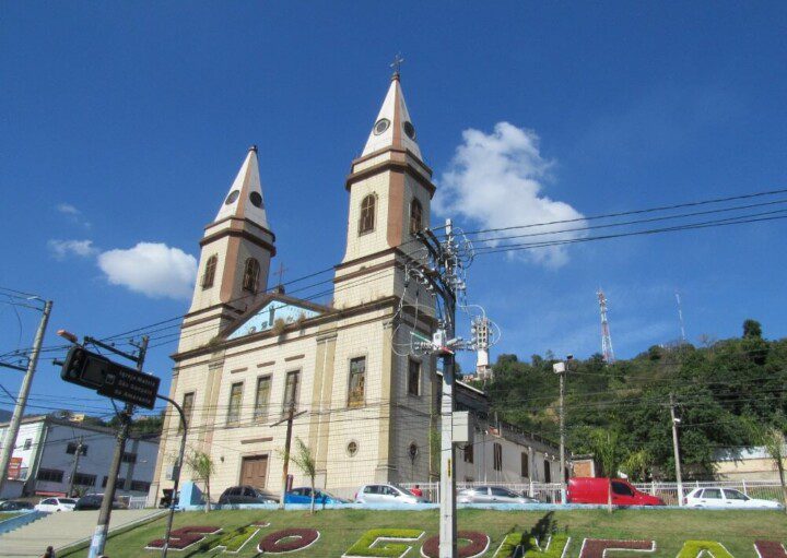 Foto que ilustra matéria sobre bairros de São Gonçalo mostra uma igreja com árvores e um céu azul ao fundo