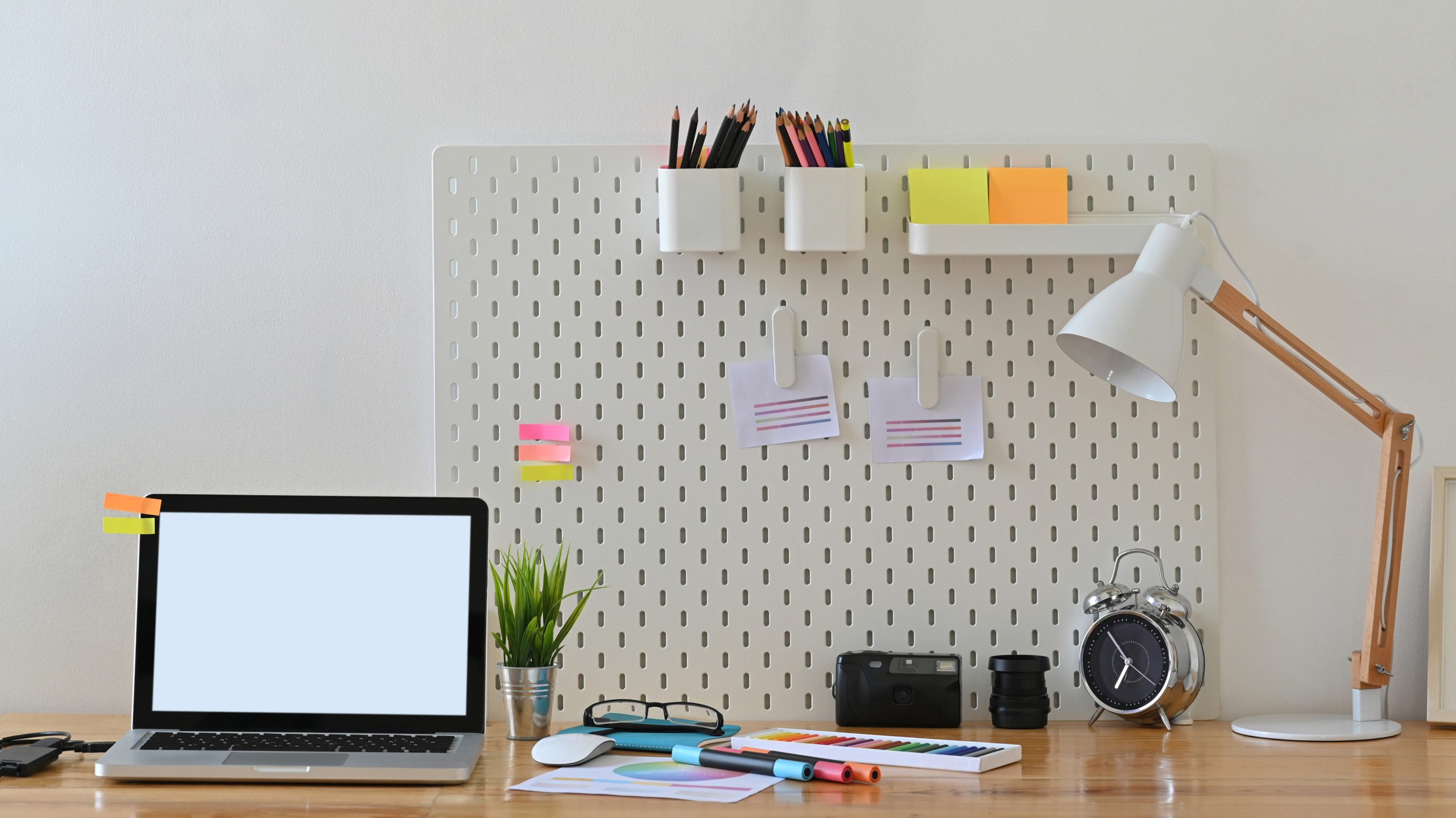 Mesa de escritório com um painel pegboard.