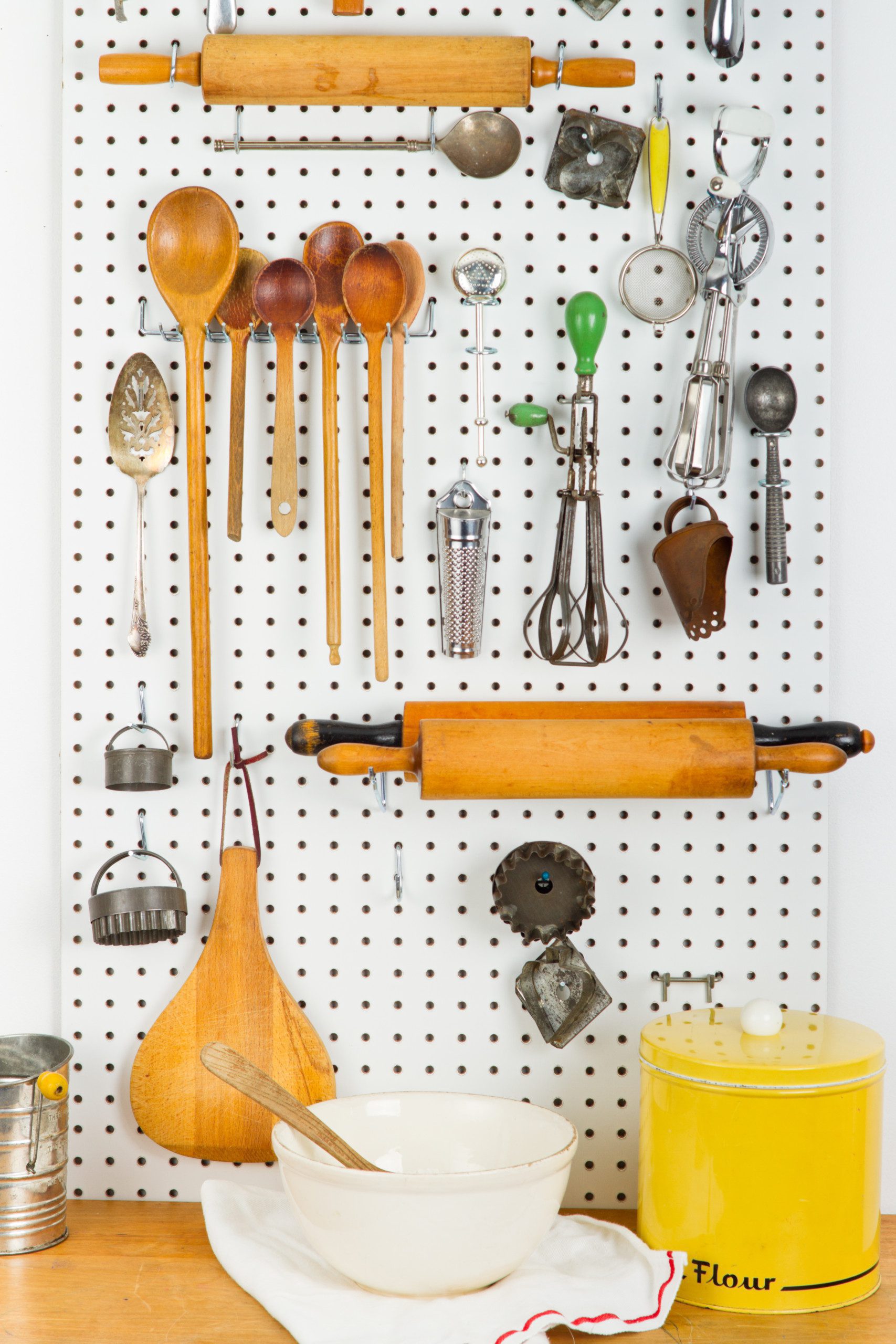 Utensílios de cozinha pendurados em um mural. 