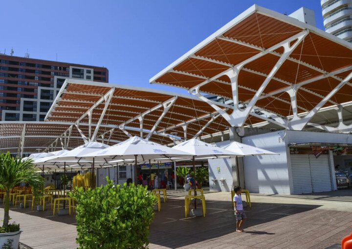 Foto que ilustra matéria sobre o Mercado dos Peixes de Fortaleza mostra a estrutura de cobertura metálica que cobre o estabelecimento.