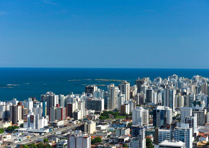 Foto que ilustra matéria sobre bairros de Vila Velha mostra uma visão aérea do bairro Praia da Costa, com muitos prédios e o mar ao fundo. (Foto: Vitor Jubini | MTur)