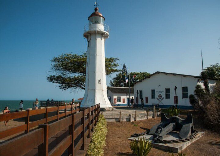 Foto mostra o Farol de Santa Luzia em um dia de sol com céu azul