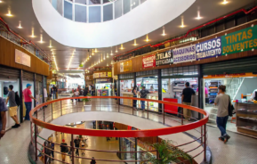 Imagem do primeiro piso do centro comercial Galeria do Rock em São Paulo, que mostra pessoas e andando pelos corredores e lojas abertas. Foto de Mike Peel