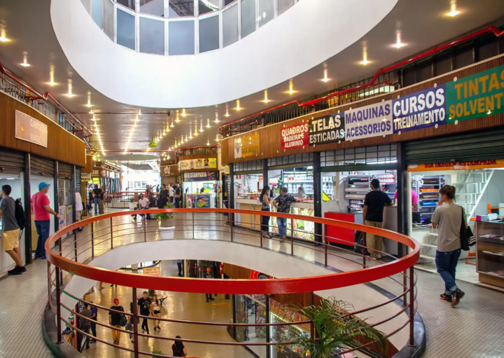 Imagem do primeiro piso do centro comercial Galeria do Rock em São Paulo, que mostra pessoas e andando pelos corredores e lojas abertas. Foto de Mike Peel