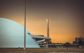 Foto mostra a lateral do Compplexo Cultural da República com o céu alaranjado do cair da noite ao fundo