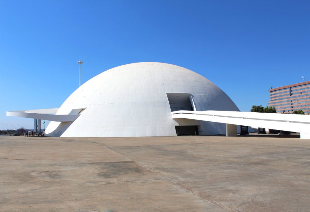 Foto que ilustra matéria sobre o Complexo Cultural da República mostra a redoma do prédio vista de frente em um dia de céu azul.