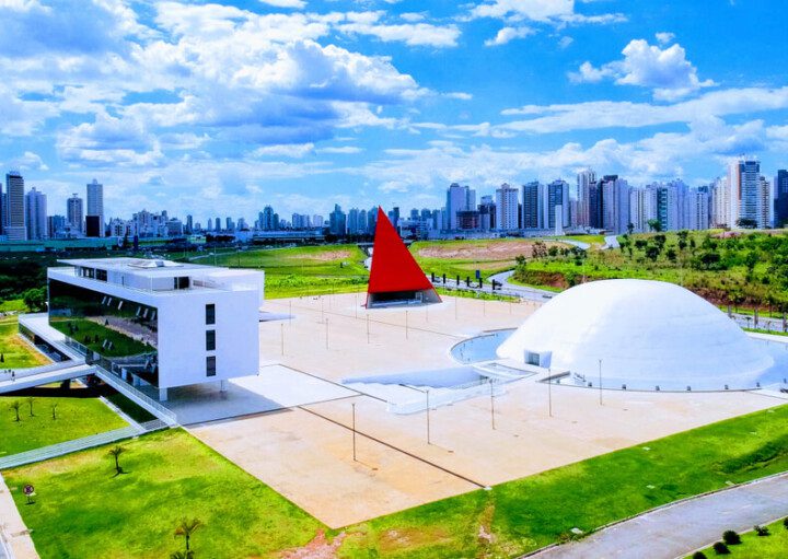 Foto que ilustra matéria sobre o Centro Cultural Oscar Niemeyer mostra o complexo visto de cima em um dia de céu azul com nuvens brancas ao fundo.