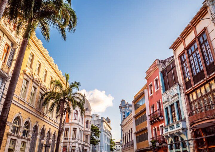 Prédios históricos, árvores e um céu azul fazem parte da paisagem desta fotografia do Centro Histórico de Recife.