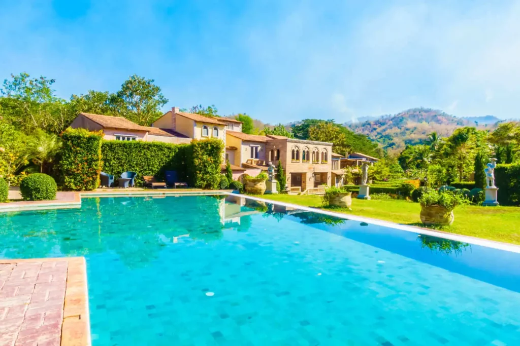 Imagem de uma piscina em uma área verde com grama e árvores para ilustrar matéria sobre condomínios luxuosos de São Paulo