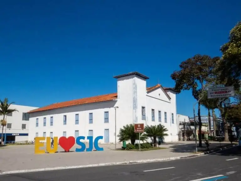 Imagem da Igreja de São Benedito, em São José dos Campos, mostra a igreja, um letreiro onde está escrito "Eu amo São José dos Campos", uma pista e vegetação com plantas e árvores em um dia de céu azul para ilustrar matéria sobre melhores cidades para morar em SP no interior do estado. Foto: Shutterstock