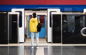 Imagem panorâmica de uma mulher em frente a um trem de porta aberta na estação para ilustrar matéria sobre o metrô Artur Alvim, em São Paulo