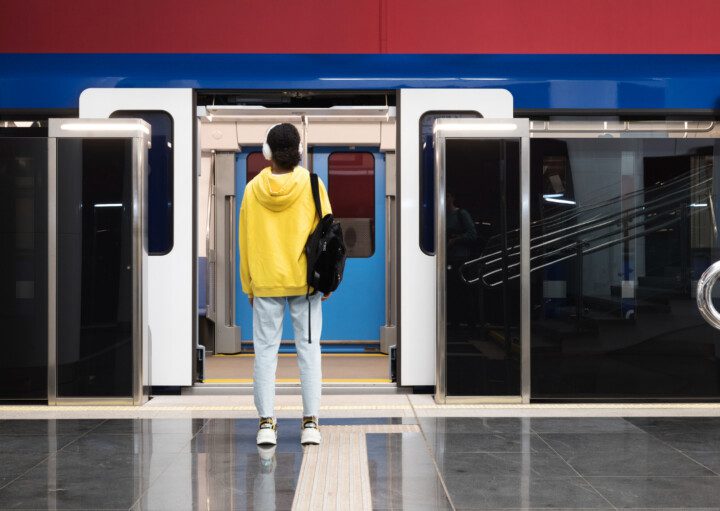 Imagem panorâmica de uma mulher em frente a um trem de porta aberta na estação para ilustrar matéria sobre o metrô Artur Alvim, em São Paulo