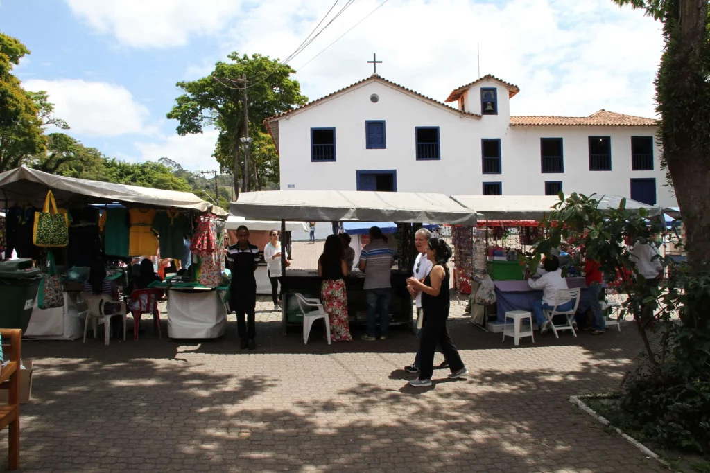 Imagem de pessoas andando por barracas de artesanato no Centro de Embu das Artes para ilustrar matéria sobre o que fazer em Embu das Artes com crianças
