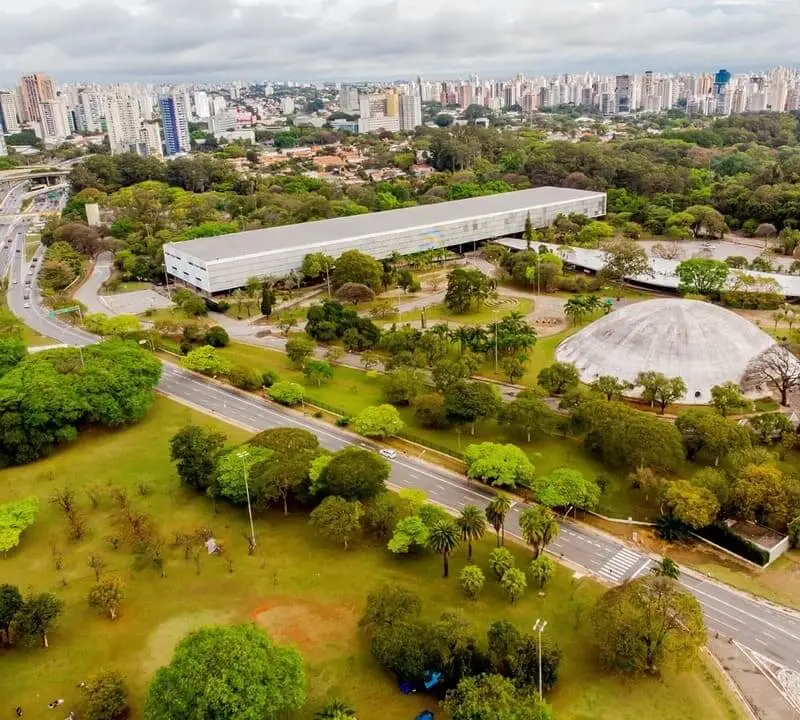 Imagem da vista aérea do Parque Ibirapuera, em São Paulo, mostra vegetação e alguns edifícios, entre entre eles a OCA (Pavilhão Lucas Nogueira Garcez)