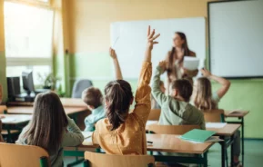 Imagem de alunos levantando as mãos em uma sala de aula para ilustrar matéria sobre as escolas particulares em Carapicuíba, em São Paulo