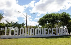 Foto que ilustra matéria sobre Bairros de Itaquaquecetuba mostra um letreiro com o nome da cidade sobre um gramado