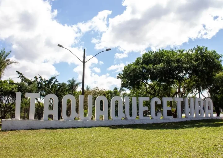 Foto que ilustra matéria sobre Bairros de Itaquaquecetuba mostra um letreiro com o nome da cidade sobre um gramado