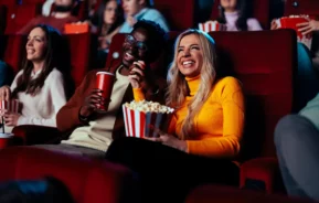 Pessoas se divertindo em uma sala de cinema de rua do RJ.