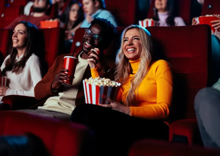 Pessoas se divertindo em uma sala de cinema de rua do RJ.