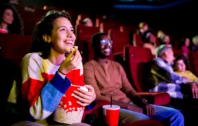 Pessoas se divertem em uma sala de cinema de rua de São Paulo.