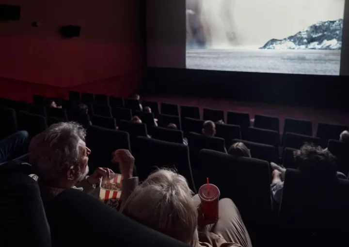 Pessoas assistindo um filme em uma sala de cinema em BH.