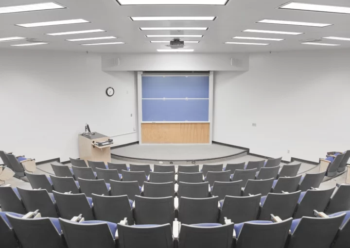 Imagem de sala de aula moderna com mesas, cadeiras e lousa para ilustrar matéria sobre faculdades em Florianópolis