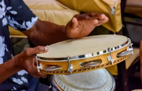 Um homem tocando pandeiro em uma roda de samba no Rio de Janeiro.