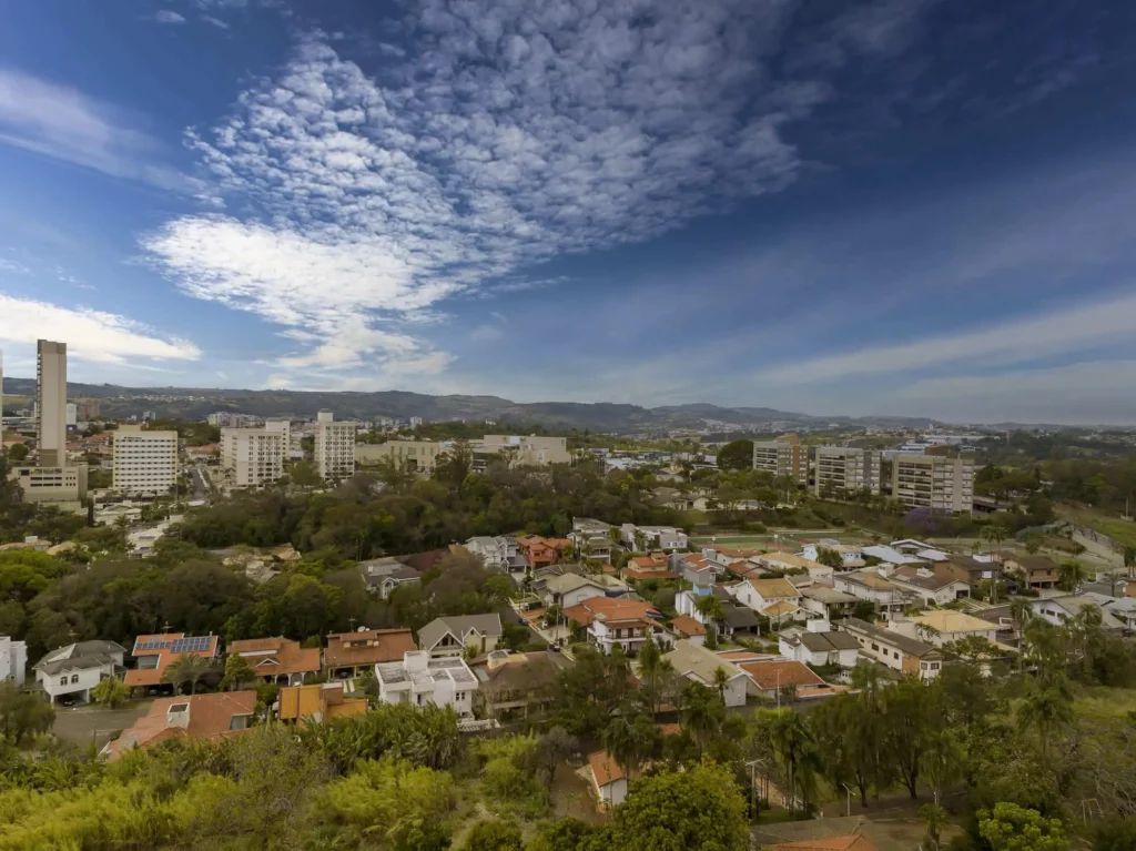 Imagem da vista aérea do cenário urbano de Valinhos, em São Paulo, mostra vegetação, casas e prédios para ilustrar matéria sobre a cidade mais segura de SP