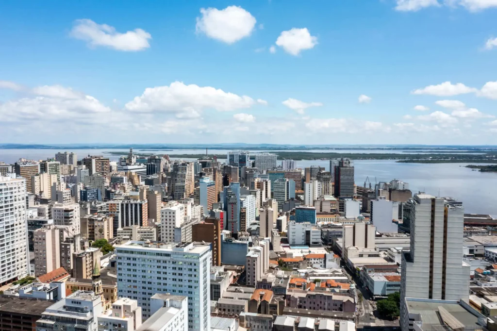 Imagem da vista aérea de Porto Alegre mostra prédios da cidade e rio ao fundo para ilustrar matéria sobre os melhores lugares para morar no Brasil