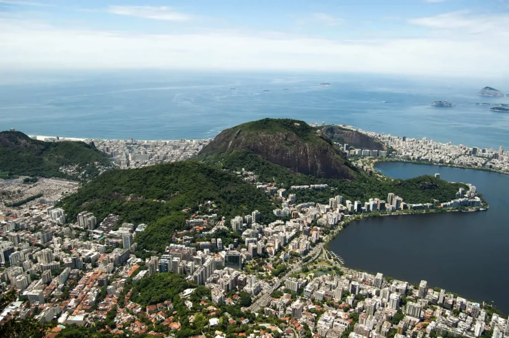 Imagem da vista aérea da cidade do Rio de Janeiro mostra morros, cidade e o mar ao fundo para ilustrar matéria sobre o que fazer com chuva no Rio de Janeiro