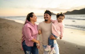 Fotografia de família passeando na praia.