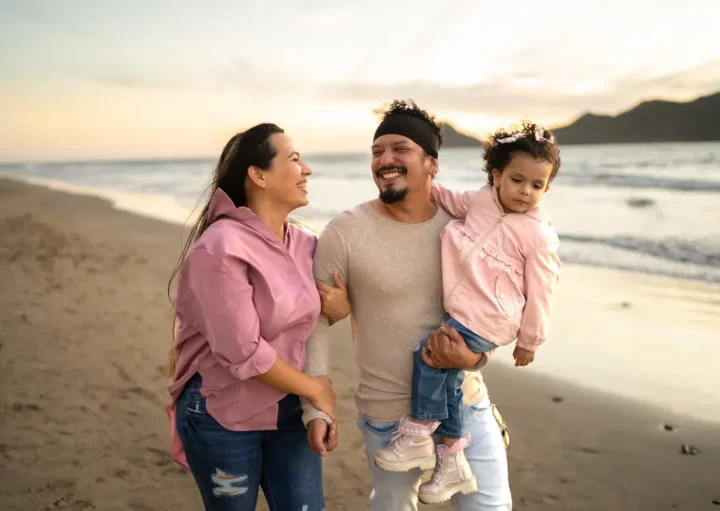 Fotografia de família passeando na praia.