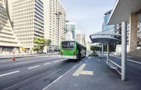 Imagem de uma parada de ônibus com um ônibus verde na Avenida Paulista, em São Paulo, para ilustrar matéria sobre cidades com o melhor transporte público do Brasil