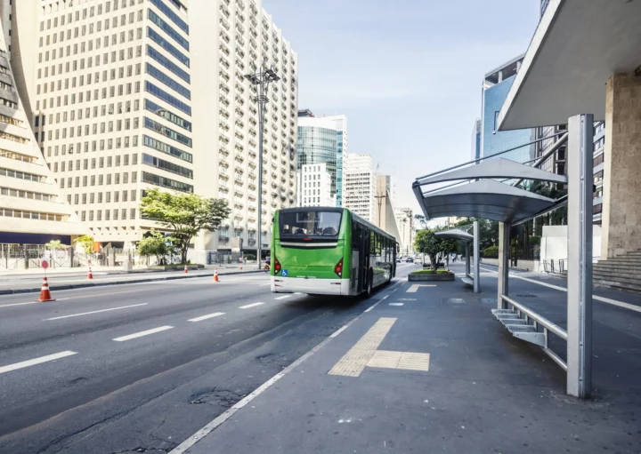 Imagem de uma parada de ônibus com um ônibus verde na Avenida Paulista, em São Paulo, para ilustrar matéria sobre cidades com o melhor transporte público do Brasil