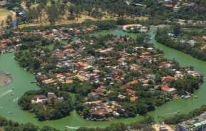 Imagem da vista aérea da Ilha da Gigóia, no Rio de Janeiro, mostra água, vegetação e casas na ilha