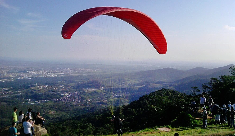 Imagem de uma pessoa voando de parapente no Pico do Urubu, em Mogi das Cruzes, para ilustrar matéria sobre o que tem para fazer em Mogi das Cruzes.