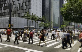 Imagem de pessoas atravessando uma faixa de pedestres na Avenida Paulista, em São Paulo, para ilustrar matéria sobre as cidades mais populosas do Brasil
