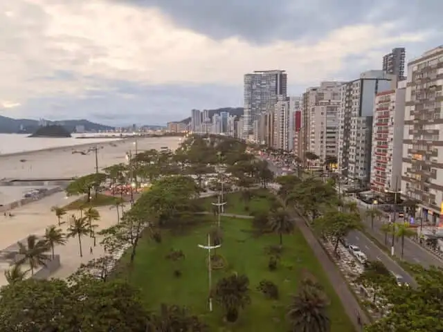 Imagem da vista aérea da orla, vegetação e prédios de Gonzaga, um dos bairros em Santos