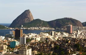 Imagem da vista aérea do Rio de Janeiro mostra prédios, mar e o Pão de Açúcar ao fundo para ilustrar matéria sobre as melhores capitais do Brasil