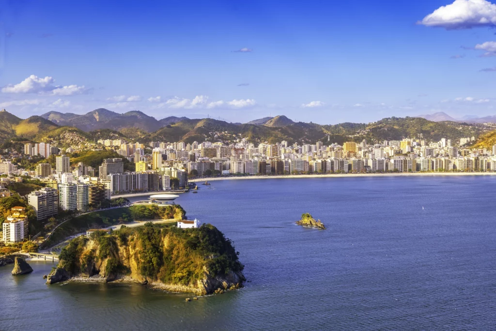 Imagem do cenário urbano de Niterói, no Rio de Janeiro, mostra prédios, mar e faixa de areia