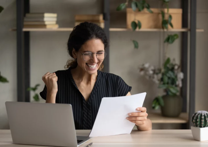 Imagem de uma mulher recebendo uma notícia boa em um contrato para ilustrar matéria sobre: "fui contemplado no consórcio, preciso comprovar renda?"