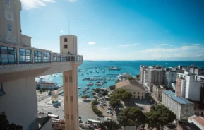 Foto que ilustra matéria sobre as Cidades mais populosas da Bahia mostra uma das vistas mais conhecidas de Salvador, com o Elevador Lacerda à esquerda, o mar no centro e prédios à direita (Foto: Márcio Filho | Mtur)