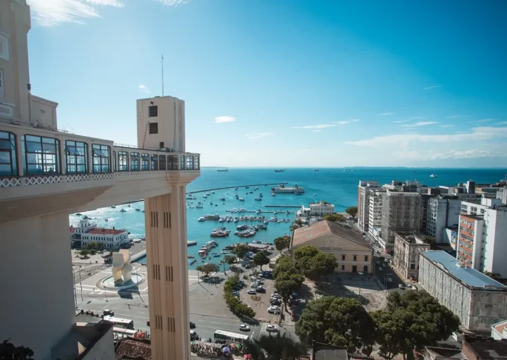 Foto que ilustra matéria sobre as Cidades mais populosas da Bahia mostra uma das vistas mais conhecidas de Salvador, com o Elevador Lacerda à esquerda, o mar no centro e prédios à direita (Foto: Márcio Filho | Mtur)