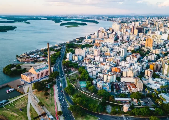 Foto que ilustra matéria sobre as Cidades mais populosas do RS mostra a cidade de Porto Alegre vista do alto, com o lago Guaíba do lado esquerdo da tela e prédios ao lado direito. (Foto: Shutterstock)