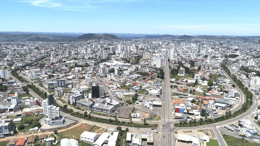 Imagem aérea da vista urbana de lages mostra avenidas, prédios e vegetação do município para ilustrar matéria sobre as cidades turísticas de Santa Catarina